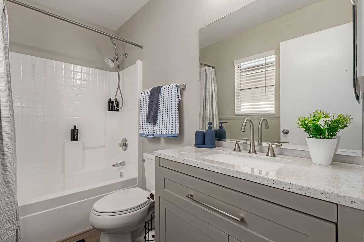A modern, well-appointed bathroom featuring a stylish vanity sink, mirrored cabinet, and a spacious shower area. The room is bright and serene, evoking a sense of relaxation and self-care.