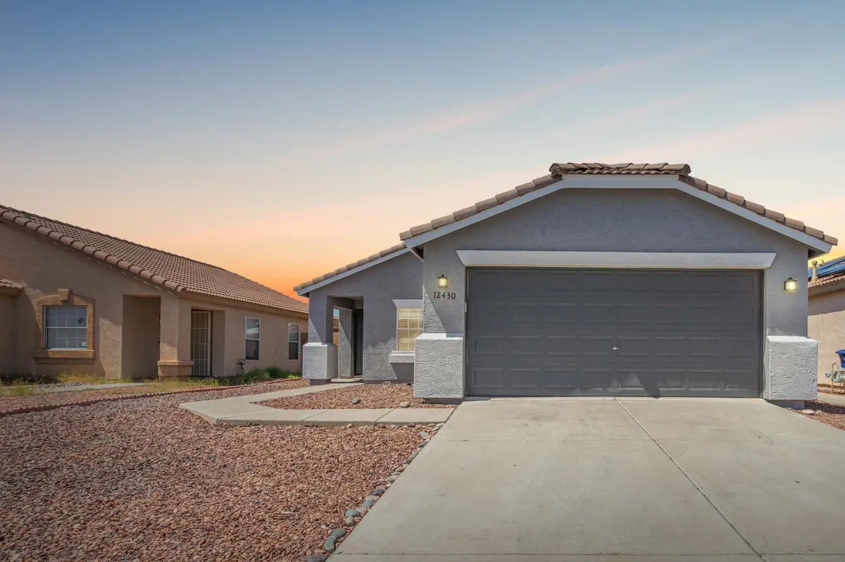 A welcoming exterior shot of the home featuring the front door, garage door, and landscaped gravel. The roofline and inviting porch create a sense of arrival, while the image hints at outdoor family-friendly activities that can take place just outside the door.